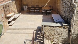 A covered outdoor patio with a table and chairs, a sofa, and a statue. - In a quiet location between Aix and Marseille. Provence. Beach 10 km away, with no buildings directly across from the property  (Lançon-Provence)