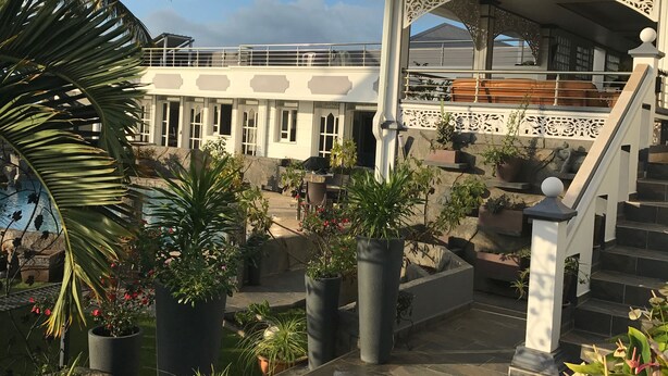 A multi-level building with a balcony, potted plants, and a staircase. - Beautiful apartment on the west coast of Reunion Island - Promo 19/05 to 22/05 (Saint Paul)