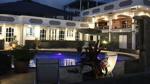 A pool area with a hot tub, potted plants, and a covered seating area. - Beautiful apartment on the west coast of Reunion Island - Promo 19/05 to 22/05 (Saint Paul)