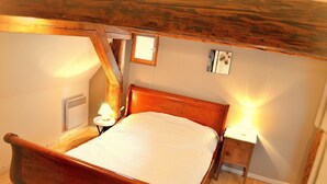 A wooden bed with a white mattress in a room with wooden beams on the ceiling. There are two bedside tables with lamps. - House Limeray, House Kayserberg Vineyard 10 people (Kaysersberg Vignoble)