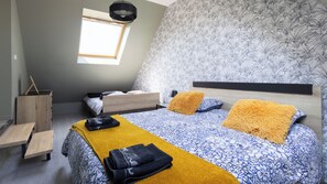 A bedroom with a bed, a window, a desk, and a wardrobe.