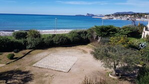 A coastal view with a paved area, greenery, and a clear blue sea. - Apartment in front of the beach, superb sea view and terrace 🏖️🏖️🏖️ (Saint-Cyr-sur-Mer)