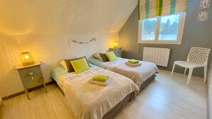 Een slaapkamer met twee bedden, een stoel en een raam met uitzicht.