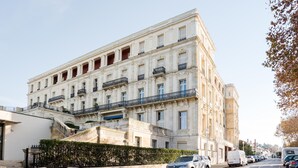 A historic building with a classical facade, multiple balconies, and a staircase leading to the entrance. - Apartment for 5 in Arcachon with secure parking (Arcachon)