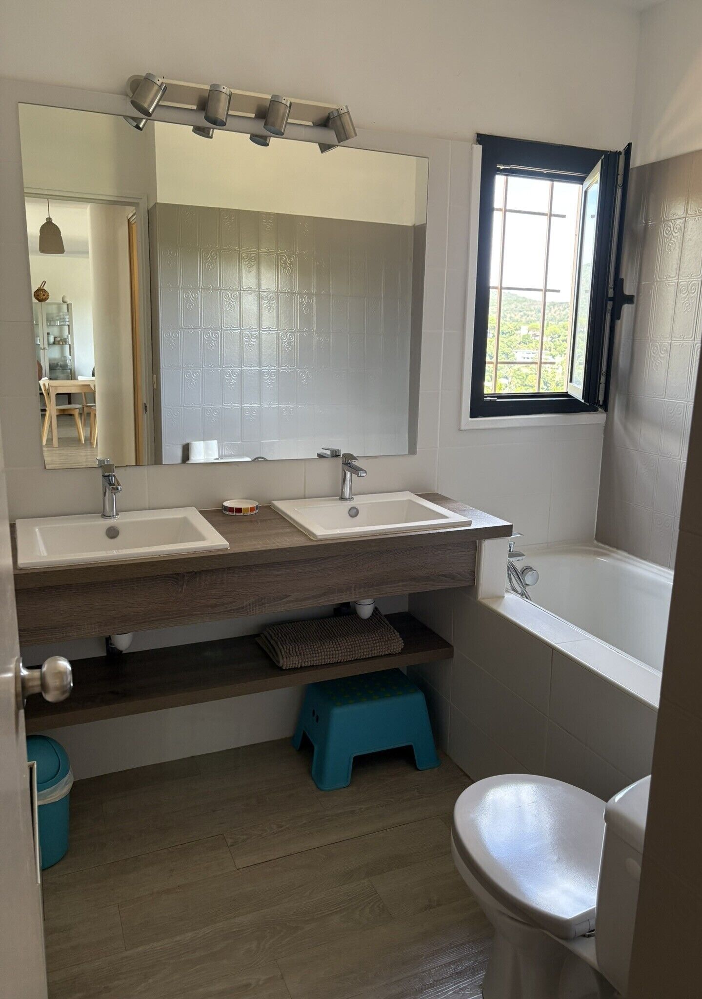 Ein Badezimmer mit zwei Waschbecken, einem Spiegel, einem Fenster, einer Badewanne und einer Toilette.