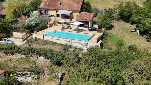 Propiedad residencial con piscina, mobiliario de exterior y jardín vallado.