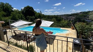 Un balcon doté d’une piscine, entouré de verdure et offrant une vue sur la ville.