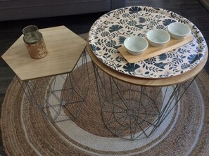 A round table with a floral patterned tablecloth, three white bowls, and a glass jar on a wooden tray. - "La Maison", heart of the village, 50 meters from the sea (Étretat)