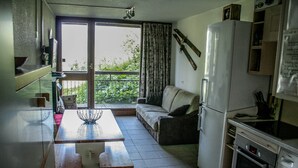 A compact kitchen with a dining table, a sofa, and a refrigerator. - Apartment at the foot of the Arc 2000 slopes (BOURG SAINT MAURICE)