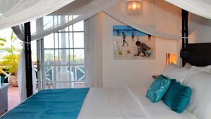 A bedroom with a bed, white curtains, a painting, and a view of the outdoors.