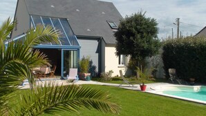 A modern house with a large glass door, a swimming pool, and a well-maintained lawn. - Villa, 300 m away, seaside, Agon-Coutainville, 7/8 people (Agon-Coutainville)
