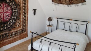 A bedroom with a bed, a tapestry, a lamp, and a wall-mounted shelf. - Villa, 300 m away, seaside, Agon-Coutainville, 7/8 people (Agon-Coutainville)