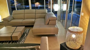A modern living room with a sectional sofa, a coffee table, and a decorative lamp.