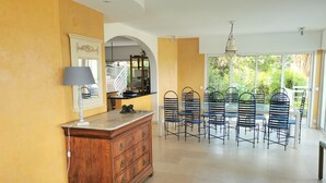 A dining area with a wooden cabinet, a lamp, and metal chairs.