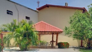 A residential property with a swimming pool, a covered patio, and a house with a red-tiled roof. - Large condo. Home away from home! (Sámara)