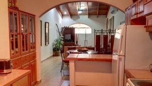 A kitchen with a central island, wooden cabinets, and a dining area with a table and chairs. - Large condo. Home away from home! (Sámara)