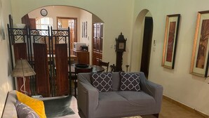 A living room with a sofa, a coffee table, and a dining area with a table and chairs. - Large condo. Home away from home! (Sámara)