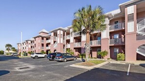 A multi-story residential building with balconies and a parking lot. - Atlantis 302D - Steps to the Ocean (St Augustine Beach)