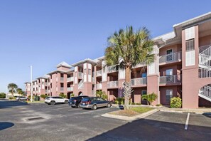 A multi-story residential building with balconies and a parking lot. - Atlantis 302D - Steps to the Ocean (St Augustine Beach)