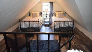 A room with two beds, a small table, and a chair.