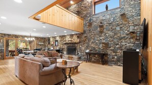 A spacious living area with a stone wall, wooden ceiling, and a fireplace. - Beautiful 6 Bed/4.5 Bath - Close To 7 Springs & Laurel Highlands Attractions (Champion)