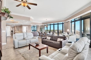 Relax in this open-plan living area with a seating arrangement featuring a sofa and two armchairs.