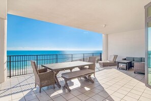Enjoy ocean views from this balcony with a table, chairs, and sofa.