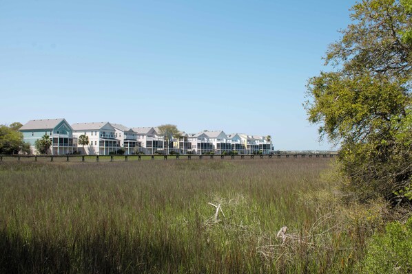 A coastal building with multiple units, surrounded by a natural landscape.