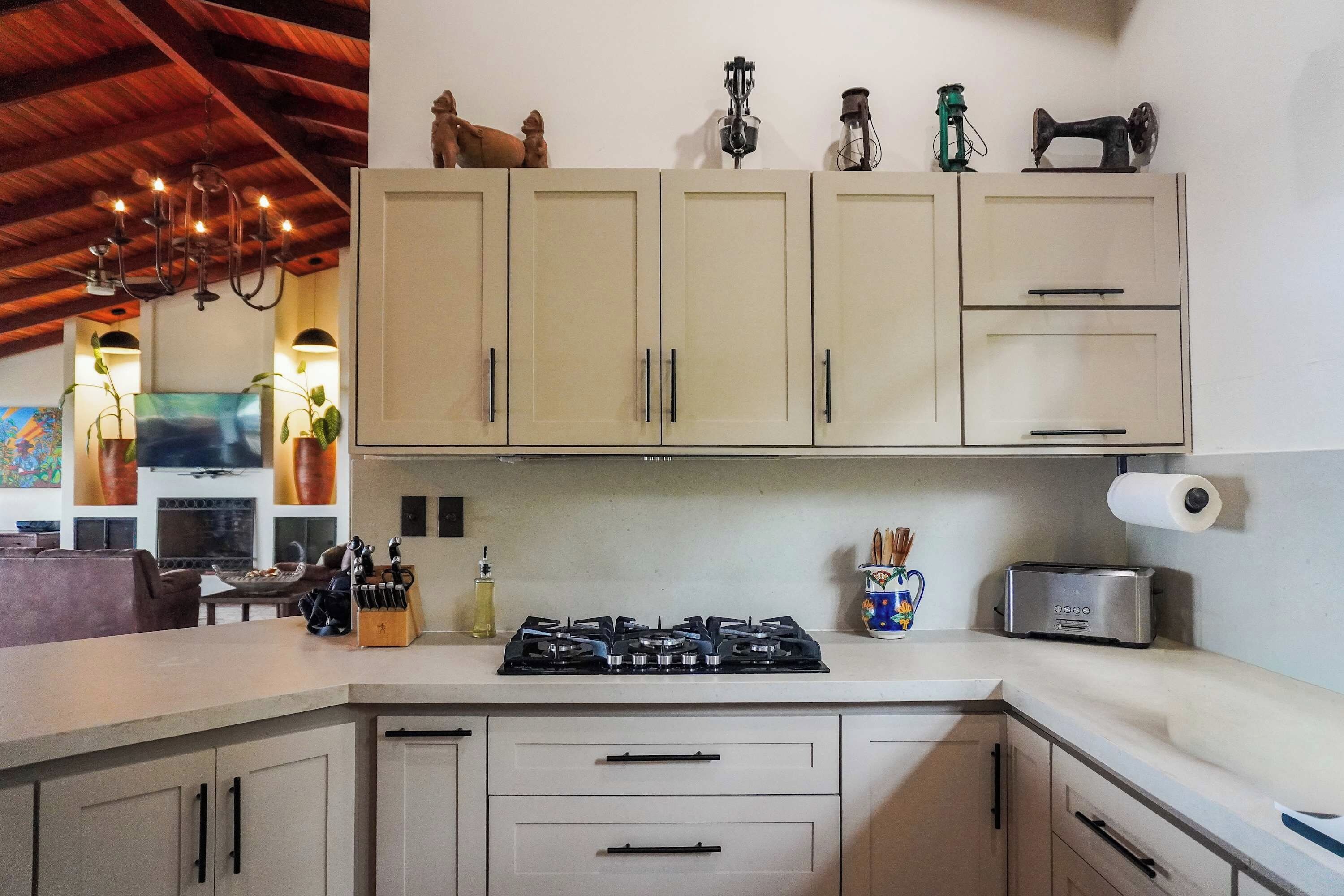 Une cuisine équipée d’une cuisinière à gaz, de placards et de divers ustensiles de cuisine.