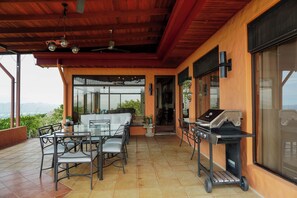 An outdoor patio with a dining area, a grill, and a view of the landscape. - Heated Infinity Pool Villa, 6BR, 25Min SJO (Alajuela)