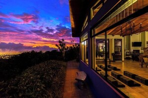 A modern building with a glass facade, a wooden deck, and a bench. - Heated Infinity Pool Retreat Villa,Yoga Deck, 6BR, 25Min SJO (Alajuela)
