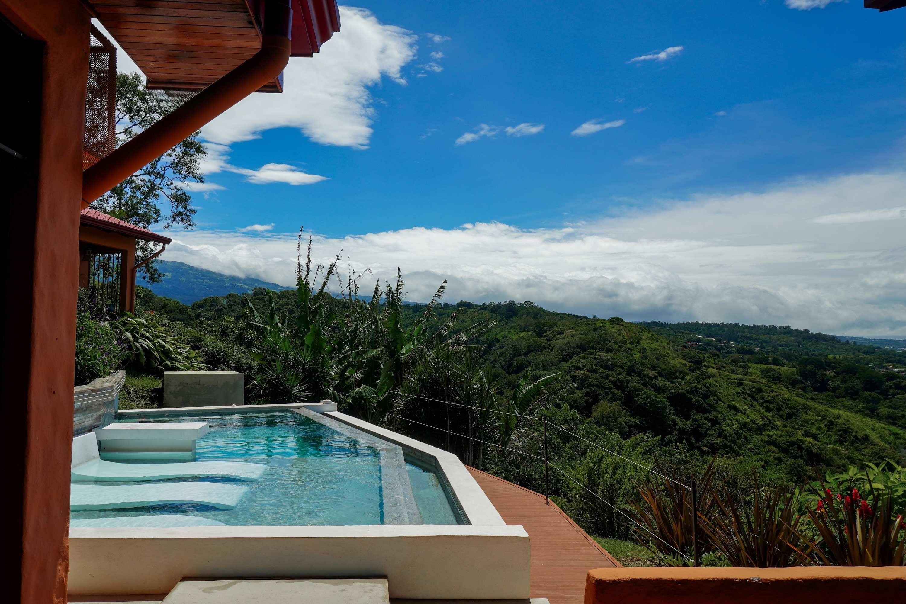 Heated infinity pool with in-pool loungers and panoramic valley views