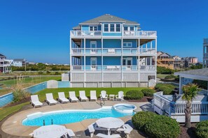A striking three-story coastal retreat with wraparound balconies on every level, where turquoise waters and sunlit skies beckon from multiple vantage points. The sparkling pool and hot tub invite you to unwind in your private oasis. - Oceanview Rodanthe Home with Pool, Hot Tub, Elevator, Game Room, and Tiki Bar (Rodanthe)