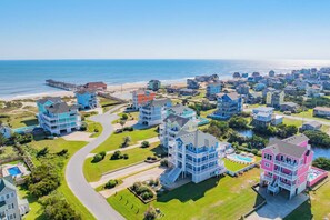 A colorful beachfront community with easy access to sandy shores and ocean adventures, framed by lush green lawns and coastal charm. - Oceanview Rodanthe Home with Pool, Hot Tub, Elevator, Game Room, and Tiki Bar (Rodanthe)