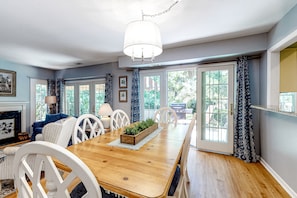 Enjoy meals in this cozy dining area with a wooden table, comfortable chairs, and a fireplace.