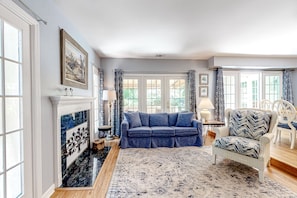 Relax in this inviting living room with a classic design, featuring a large sofa, armchair, and patterned rug.