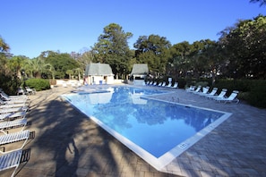 Relax by the pool surrounded by lush greenery and comfortable lounge chairs.