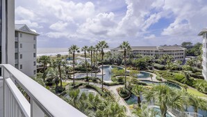Ein Resort mit mehreren Schwimmbecken, Palmen und Blick auf den Ozean.