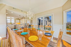 A dining area with a wooden table set for six, surrounded by chairs. - Oceanview Home w/ Private Pool, Hot Tub, and Elevator. Enjoy the HI View! (Rodanthe)