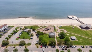 Oversigtsbillede af et kystområde med strand, parkeringsplads og legeplads.