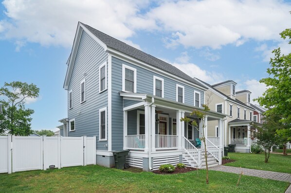 A two-story house with a front porch and a small front yard. - Big, Beautiful & Beachside Bliss - Sleeps 10! (Hampton)