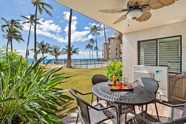 Une terrasse avec une table, des chaises et un ventilateur de plafond.