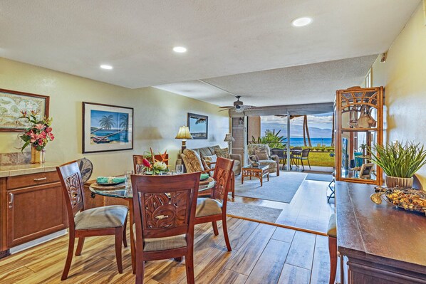 A spacious living area with a dining table, chairs, and a view of the ocean. - Ma'alaea Kai 110 - Spectacular Oceanfront/Mountain Views - Full Ducted AC (Wailuku)