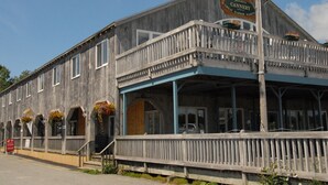 A wooden building with a balcony and flower baskets. -  Unique Marina Side Condo With Great Views And Fun Atmosphere! (Southwest Harbor)