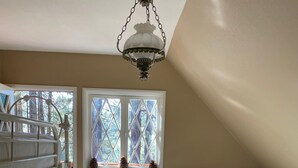 A bedroom with a bunk bed, a window with a view of trees, a decorative lamp, and a quilted bedspread. - Perfect Family Getaway,  One Light to Snow Summit, Bear Mountain and Shopping (Big Bear Lake)