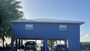 A two-story building with a flat roof and a covered parking area.