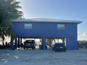 A two-story building with a flat roof and a covered parking area. - Oceanfront Sandy Beach Vacation Rental Unit 1 (Marathon)