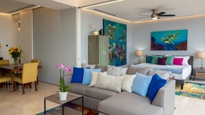 Een moderne woonkamer met een bank, salontafel en een eethoek met stoelen.