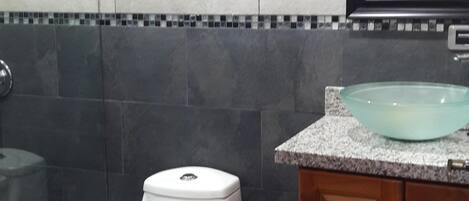A bathroom with a toilet, a sink, and a window.