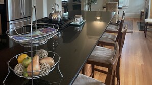 A spacious kitchen with a large island, wooden cabinets, and pendant lighting. - RELAX, RENEW, REJUVENATE! (Santa Rosa Beach)